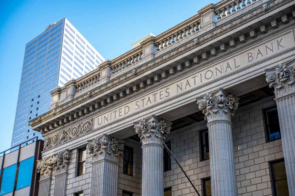 A photo of a bank building, showing scrollwork on the edge of the roof and elaborate columns